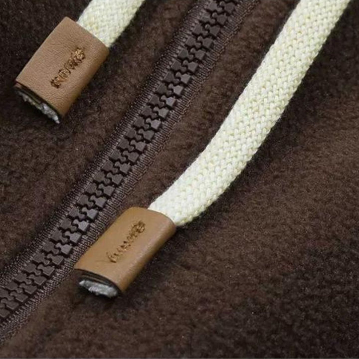 Varm og myk fleecejakke for dame med hette. Brun lappeteppedesign perfekt som høst- og vinterjakke.