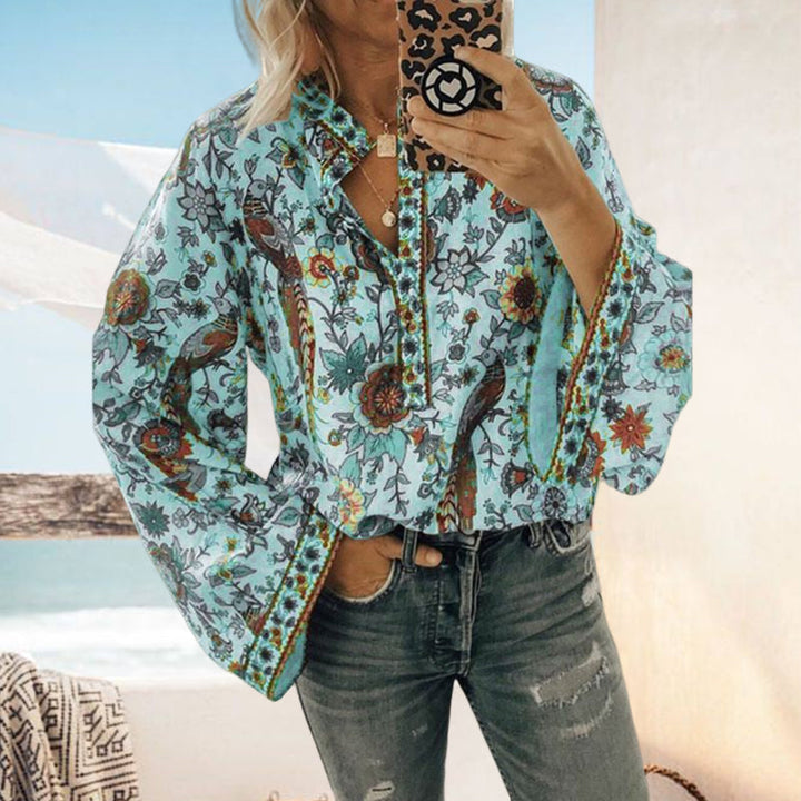 Mønstret damebluse med løs passform, knapper og elegant påfugltrykk, perfekt for vår/sommer.