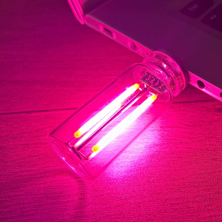 Bakgrunnsbilde av stilig nattlys i glassflaske, uthever den dekorative belysningen og USB-tilkoblingen.