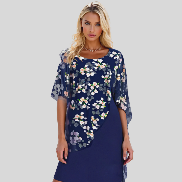 Dame a-linje chiffonkjole med blomstermønster, vist på modell. En elegant og ermeløs festkjole for sommeren.