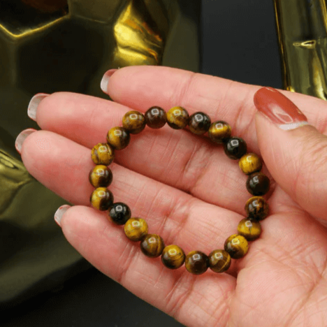 Detaljbilde av tigerøye armbåndets unike perlestruktur og farger, kvinnesmykke.