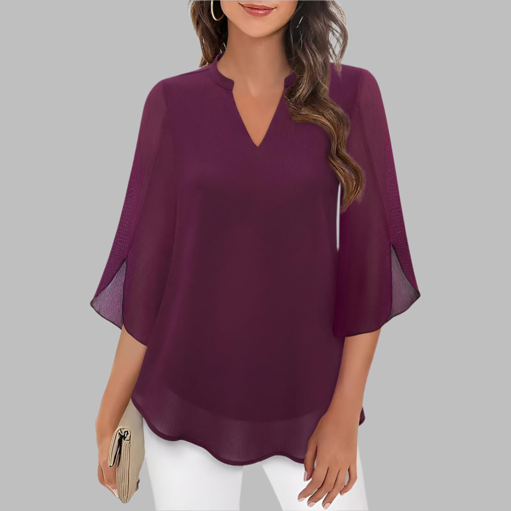 Feminin dametopp med v-hals og unike kronbladermer. En stilfull bluse for sommerdager og kvelder.
