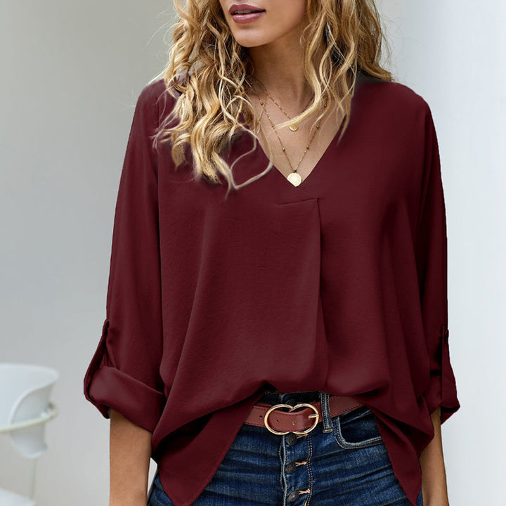 Ensfarget, elegant langermet bluse for kvinner med V-hals. Komfortabel til arbeid, fritid og ferie.
