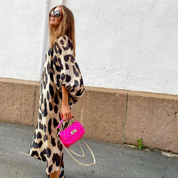 Mønstret damekjole med leoparddesign, V-hals og lange ermer. Komfortabel og chic midikjole for alle anledninger.