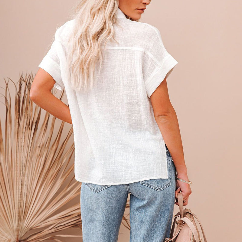 Ryggvisning av kvinners kortermet bluse med knapper. Ensfarget, elegant skjorte for vår- og sommergarderoben.