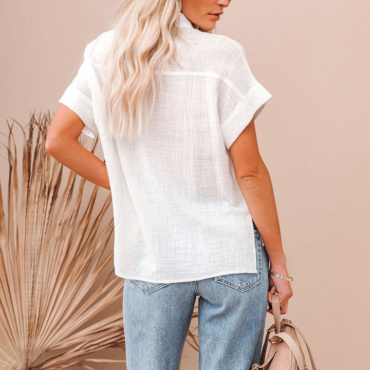 Ryggvisning av kvinners kortermet bluse med knapper. Ensfarget, elegant skjorte for vår- og sommergarderoben.