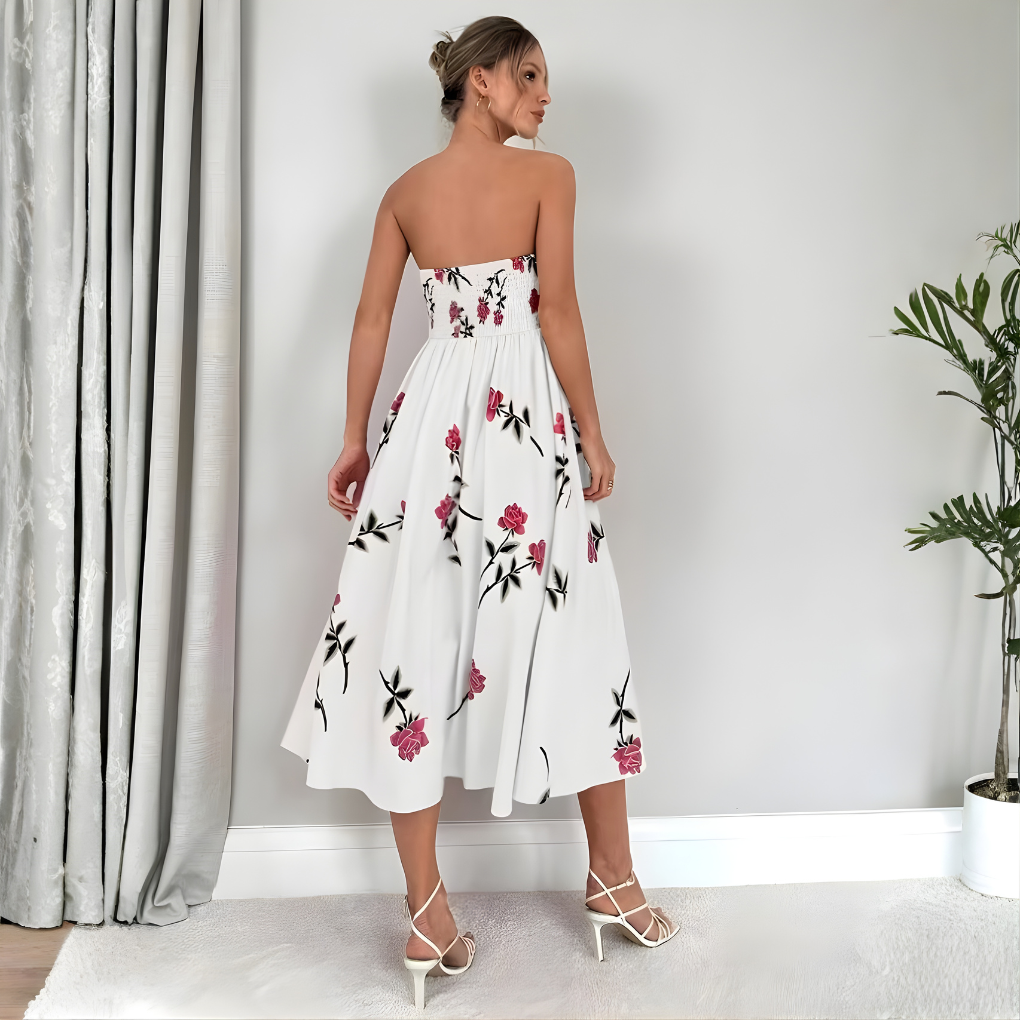 Elegant knelang damekjole med A-linjesnitt og ermeløs design. Hvit med vakkert blomstermønster for sommer.
