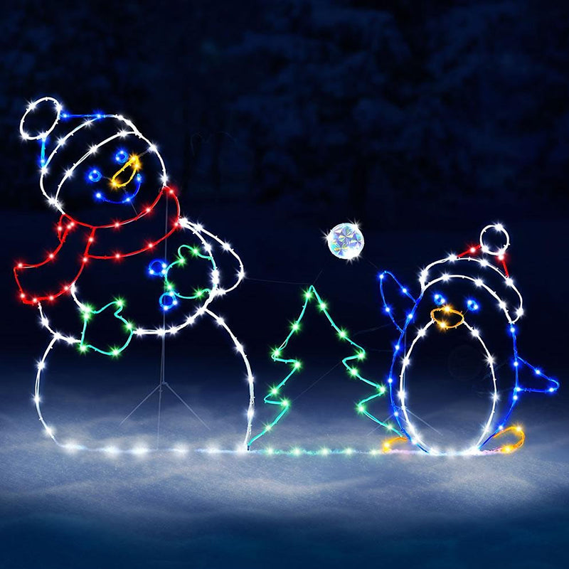 Utendørs animert juledekorasjon viser snømann og pingvin i snøballkamp. Lyser opp vinterhagen.