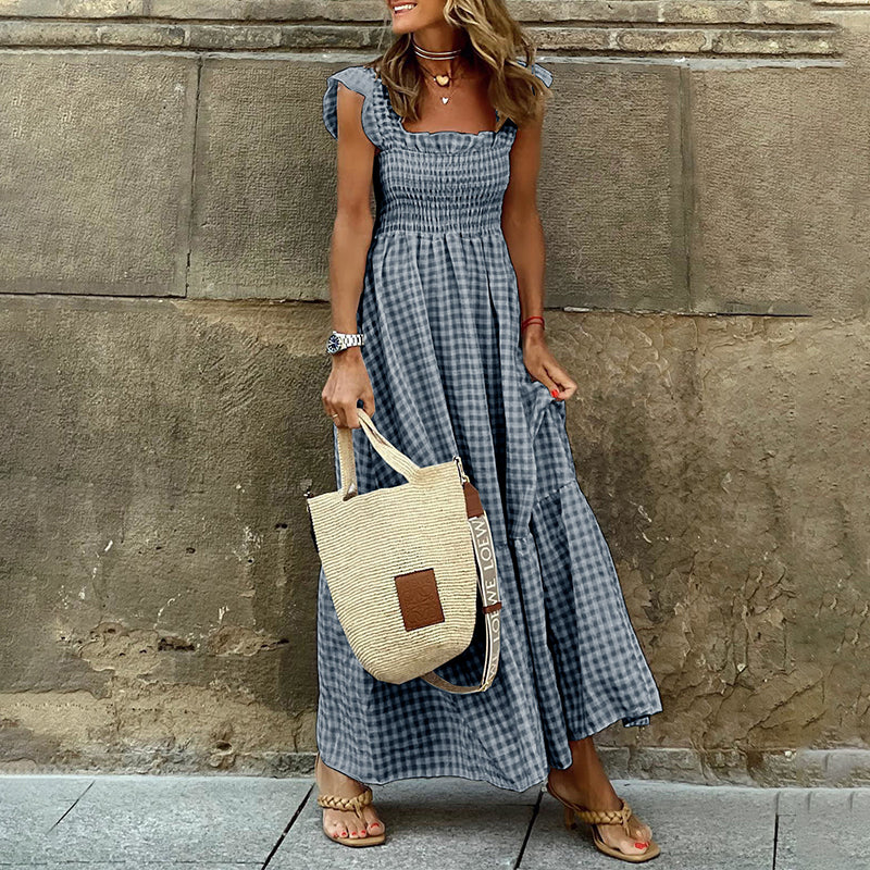 Dame i elegant rutete maxi kjole med smocked detalj. Komfortabel hverdagskjole, også perfekt for fest.