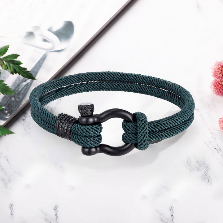 Unisex flettet tauarmbånd med anker på håndleddet, et chic og maritimt smykke.