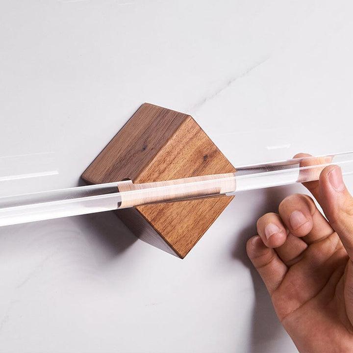 Nærbilde av håndkleholder i akryl og valnøtt, viser materialkvalitet og moderne utførelse.
