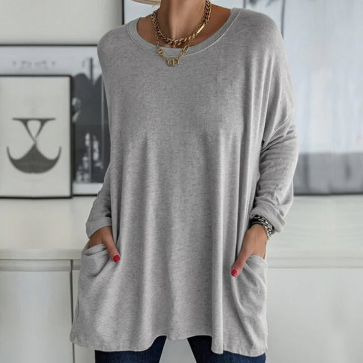 Elegant dame topp i ensfarget design, rund hals, løs passform, flott for høstklær og mote.