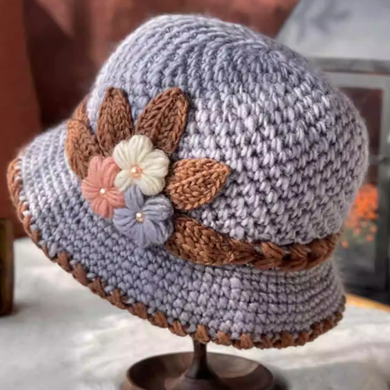 Stilfull fransk ullhatt for kvinner, tykk og varm. Blomsterdetaljer gir et elegant preg.