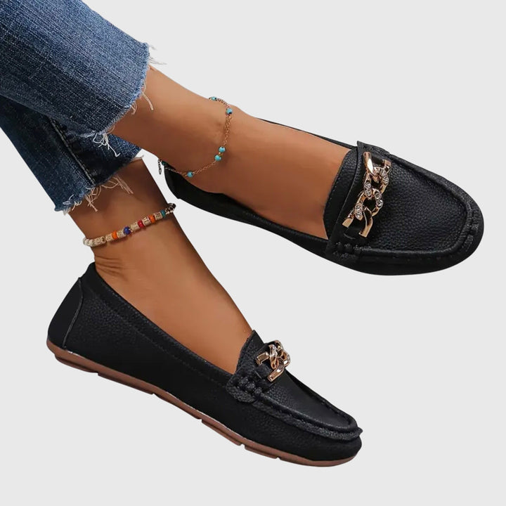 Nærbilde av den skinnende kjededetaljen på damesko. Stilige slip-on loafers med komfort.