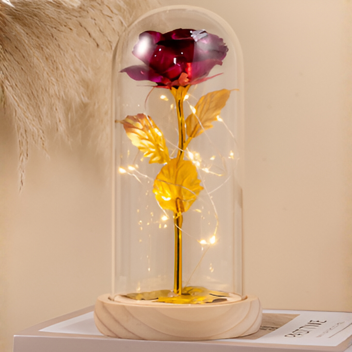 Vakker evig rose med glødende LED-lys inne i en klar glasskuppel på stabil trebase. Symbol på evig kjærlighet.