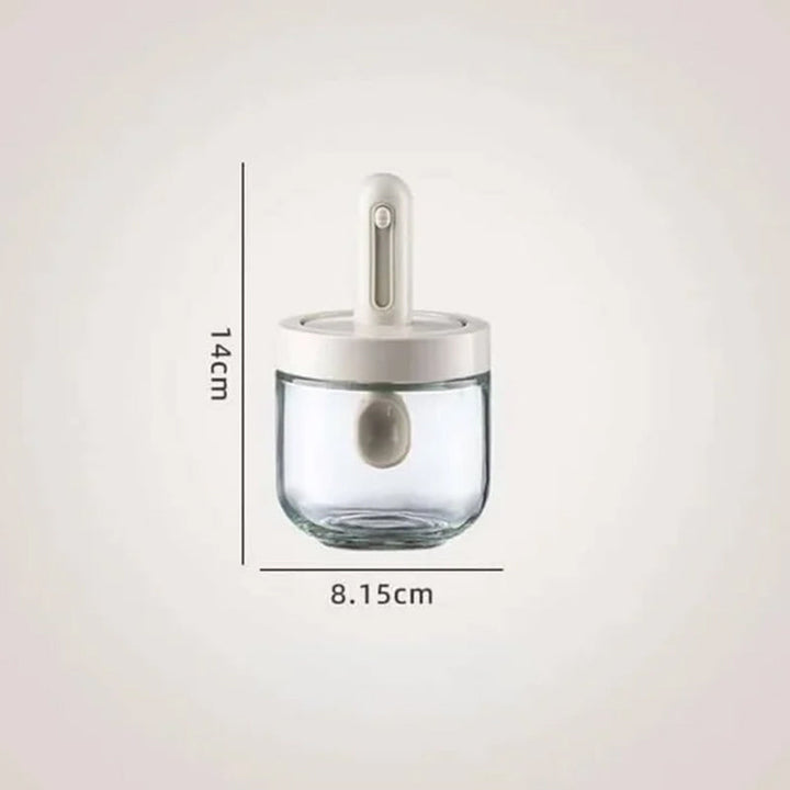 Moderne krydderkrukke i glass med justerbar skje, perfekt for et organisert og stilfullt kjøkken.