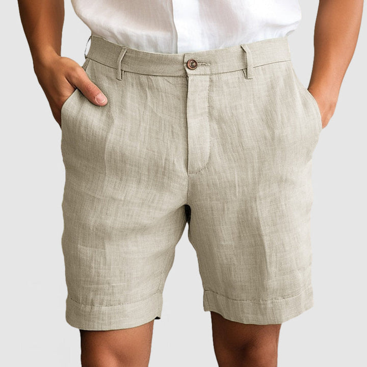 Mann iført komfortable herreshorts i beige, ideelle for avslappede sommerdager. Pustende fritidsshorts.
