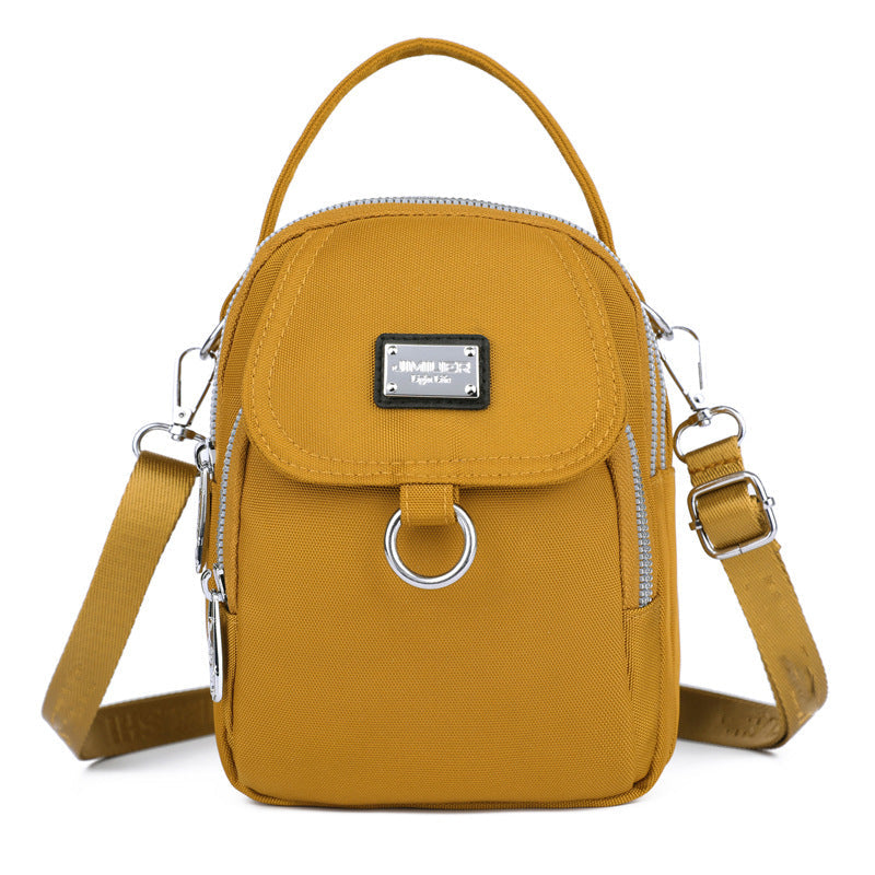 Robust nylon crossbody, vanntett og funksjonell for alle anledninger.