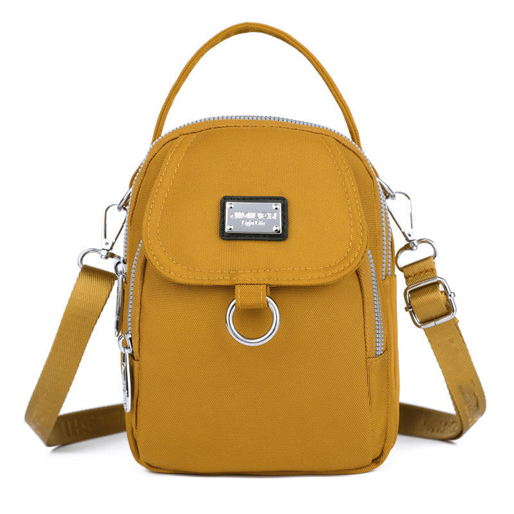 Robust nylon crossbody, vanntett og funksjonell for alle anledninger.