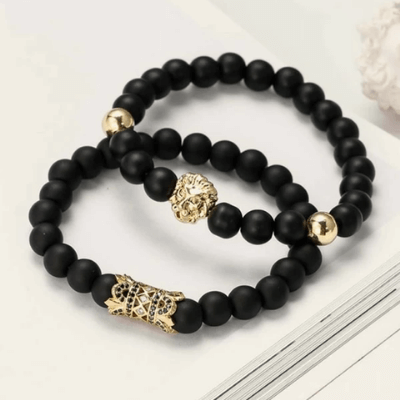 Svart løvearmbånd med mattlakkert finish og gullfarget løvehode, gir en rå og elegant stil.