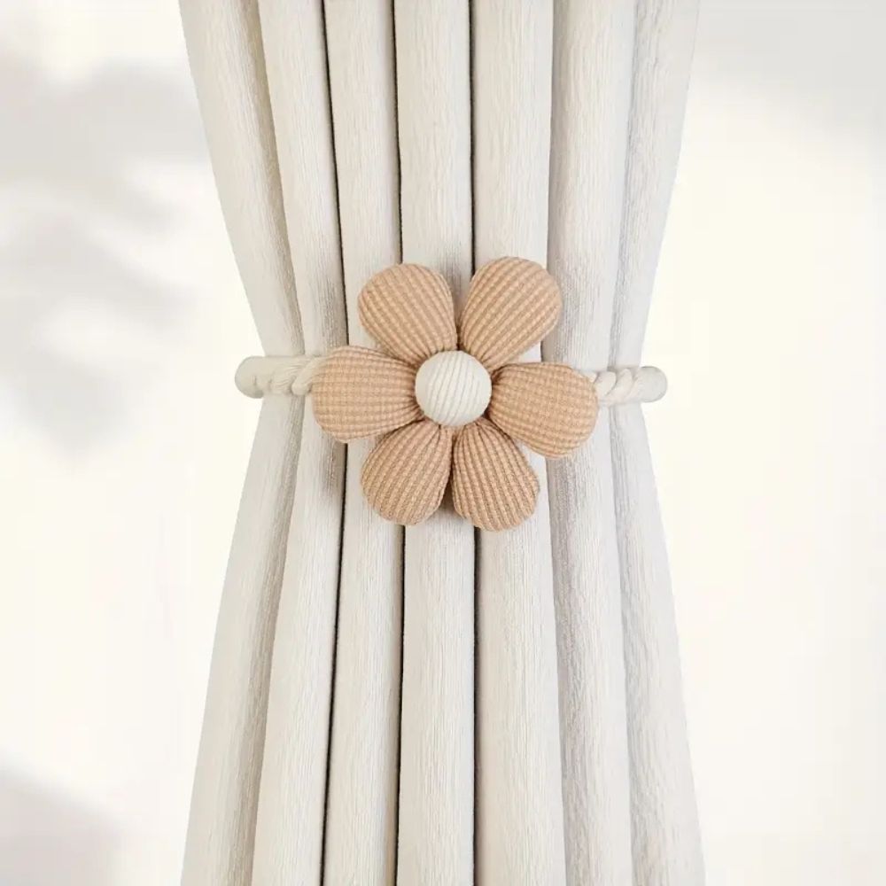 Blomsterformet magnetisk gardinholder i beige/brune nyanser. Elegant interiørdetalj til gardiner i stue og soverom.