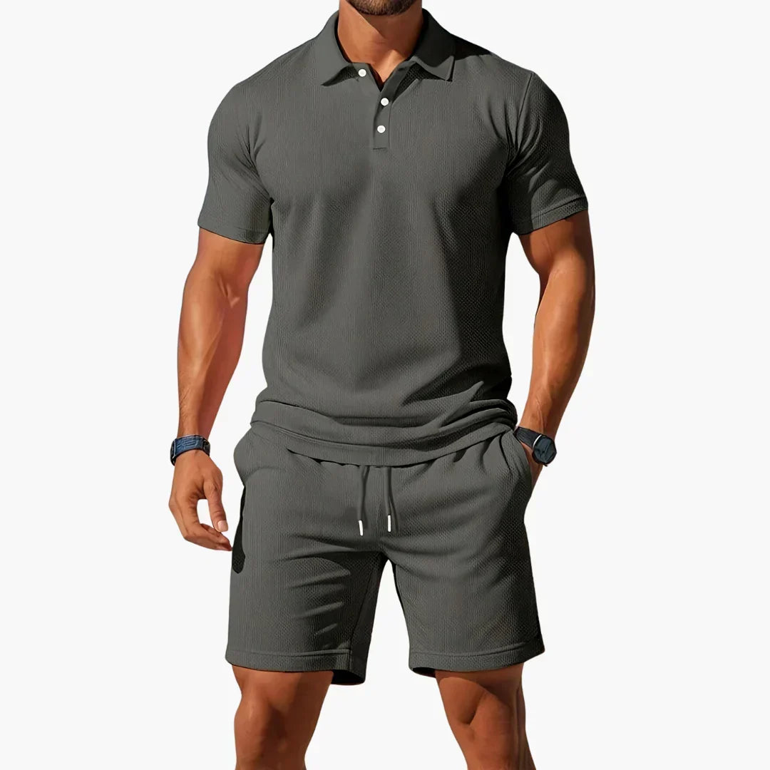 Mann nyter sommerdagen i Nathan komfortabelt poloshorts sett. Stilig og pustende herreklær for fritid.