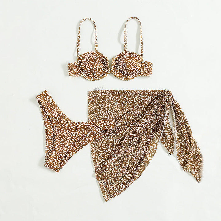 Sommerlig tredelt bikini for kvinner med moderne blomstertrykk og matchende skjørt. Ideell for ferie.