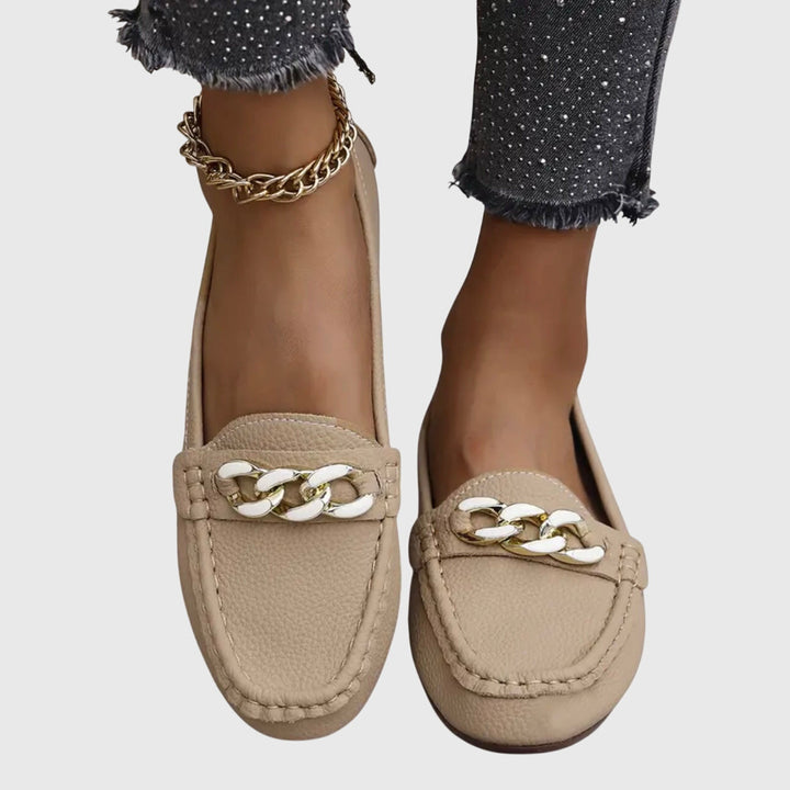 Sideprofil av elegante slip-on loafers for kvinner. Fottøy med kjededetalj og god komfort.