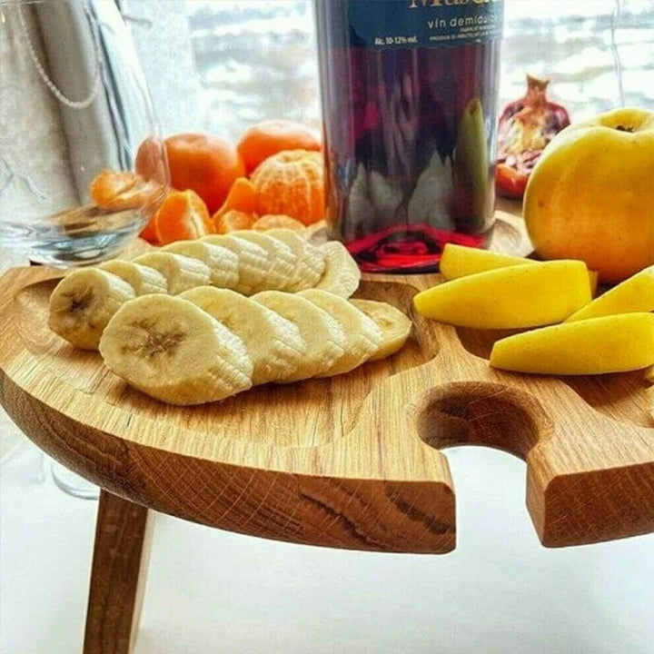 Sammenleggbart tre piknikbord, fungerer som serveringsbrett for snacks og vin utendørs.