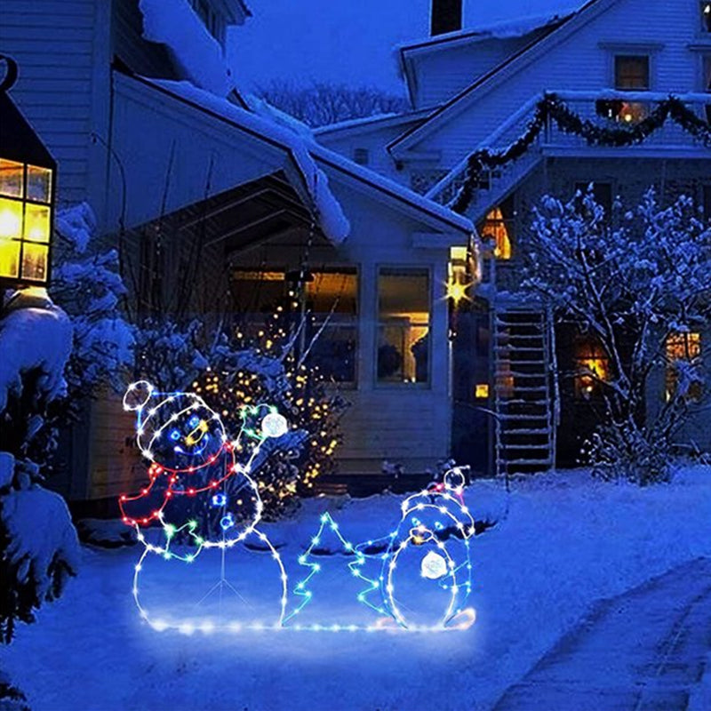 Detalj av animert juledekorasjon: snømann og pingvin kaster snøballer. Ideell utendørs hagedekorasjon.