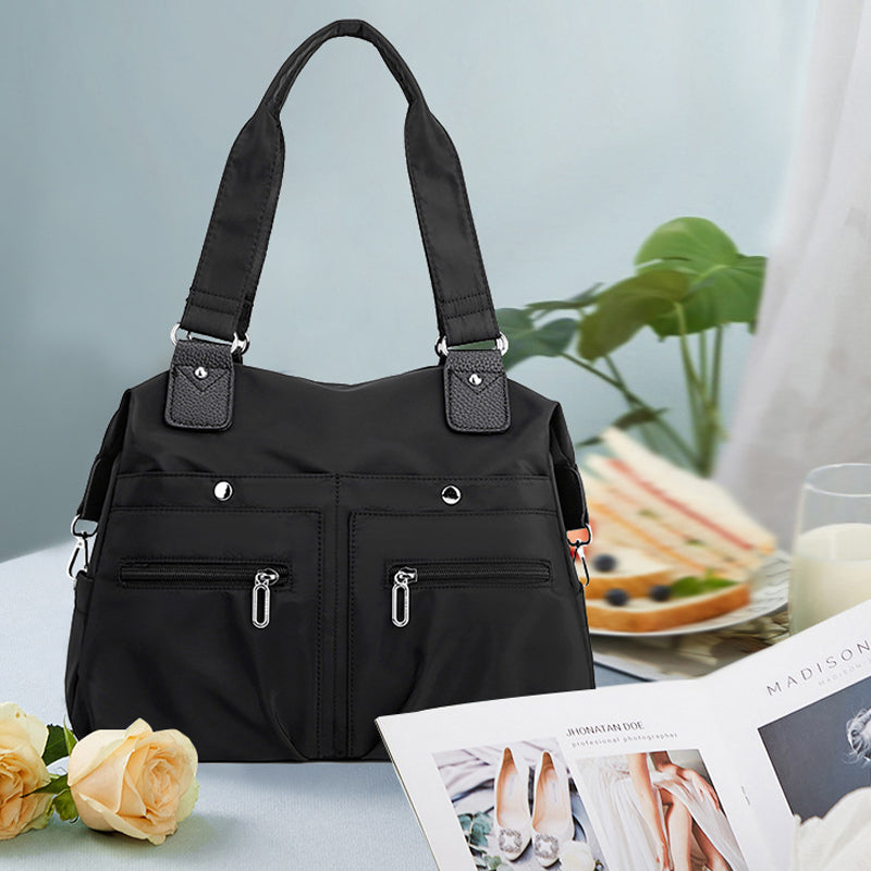 Moderne vanntett skulderveske i nylon. Perfekt laptopveske for den stilbevisste kvinne på farten.