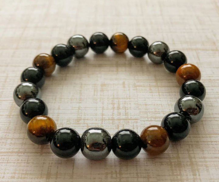 Nærbilde av unisex natursteinarmbånd. Detaljer av tigerøye, obsidian, hematitt for balanse og beskyttelse.