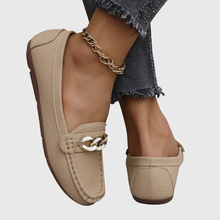 Fremvisning av tåboksen på stilige slip-on loafers for kvinner. Elegant fottøy med kjededetalj.