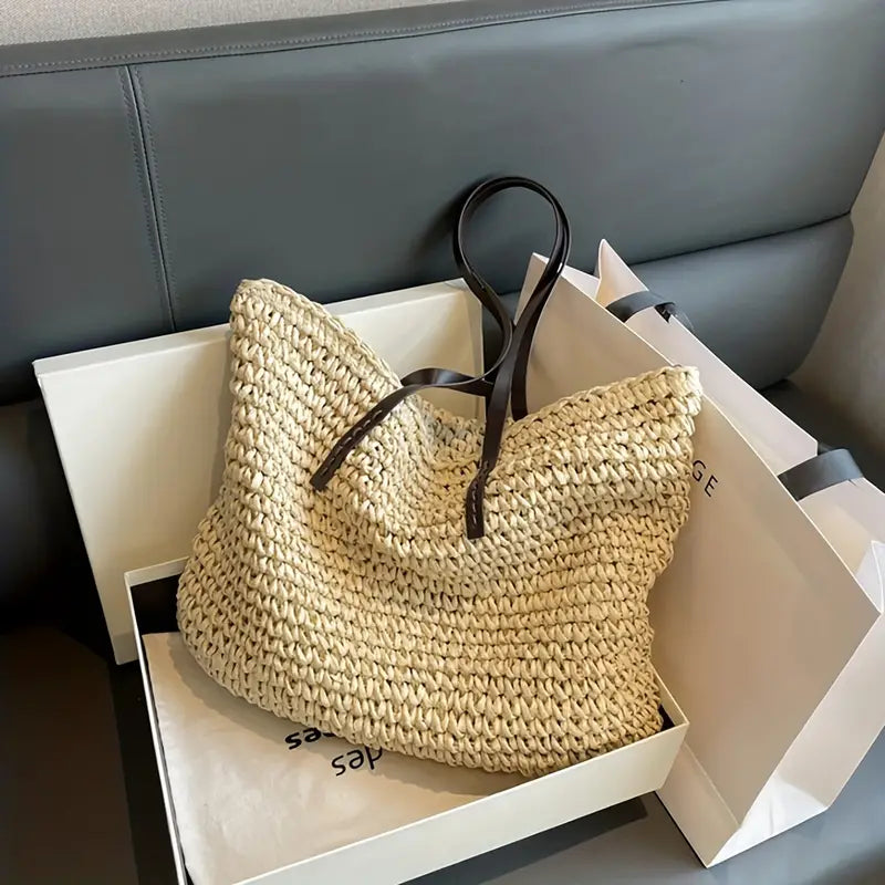 Kvinne bærer elegant vevd skulderveske med lærstropper; ideell for strand, by eller hverdag.
