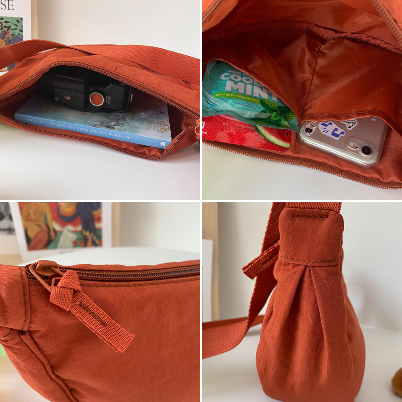Kompakt halvmåne reiseveske i nylon, unisex crossbody, sikker og enkel tilgang til eiendeler.