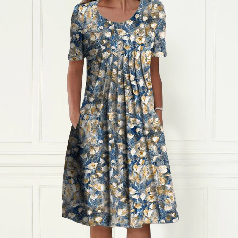Ryggvisning av en kortermet damekjole med blomstertrykk. Ledig passform i lett polyester.