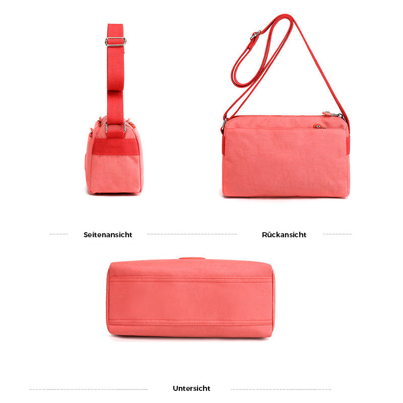 Innhold: Nøkler, telefon og lommebok i flerlags nylon crossbody-veske, viser romslighet.