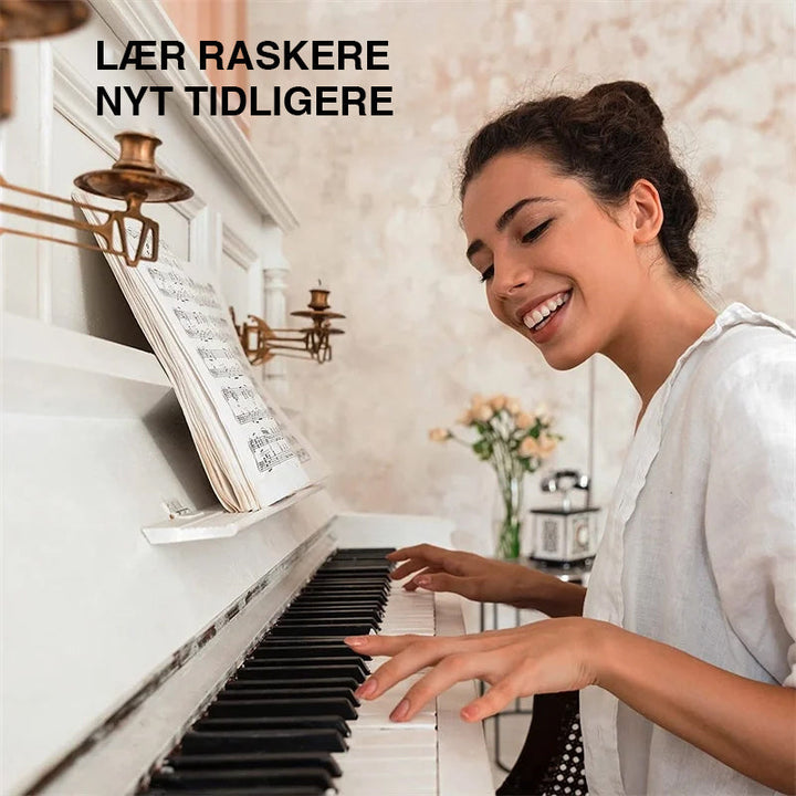 Nærbilde av silikonnoter som passer perfekt mellom tastene på et pianoklaviatur for enkel veiledning.