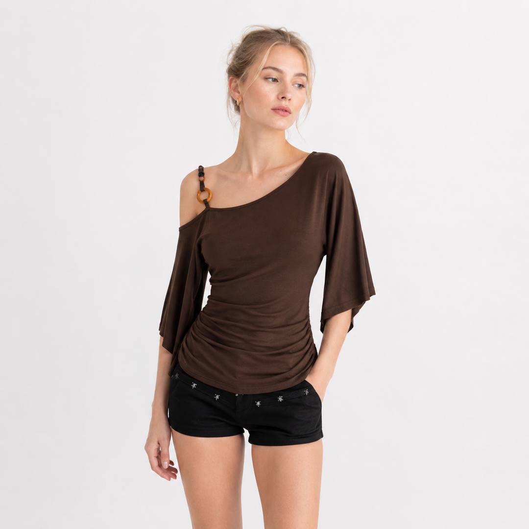 Asymmetrisk off-shoulder topp i kaffe farge for dame, med elegante perledetaljer og drapert design for sommer.