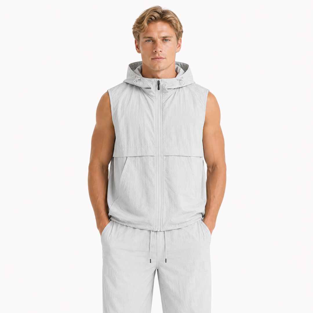 Mann iført ermeløs hettevest i streetwear-stil. Funksjonell og komfortabel for urban fritid og utendørsaktiviteter.