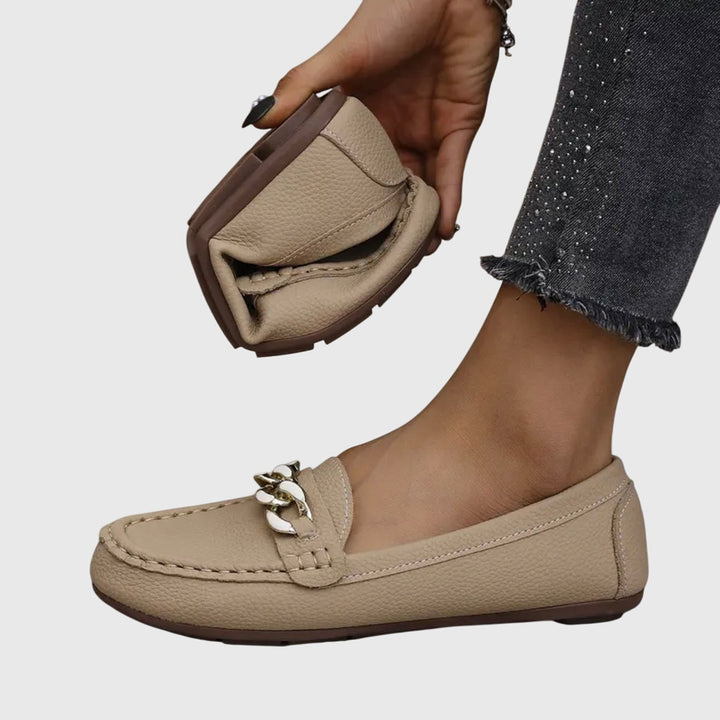 Ovenfra-bilde av kvinners komfortable slip-on loafers med en iøynefallende kjededetalj.