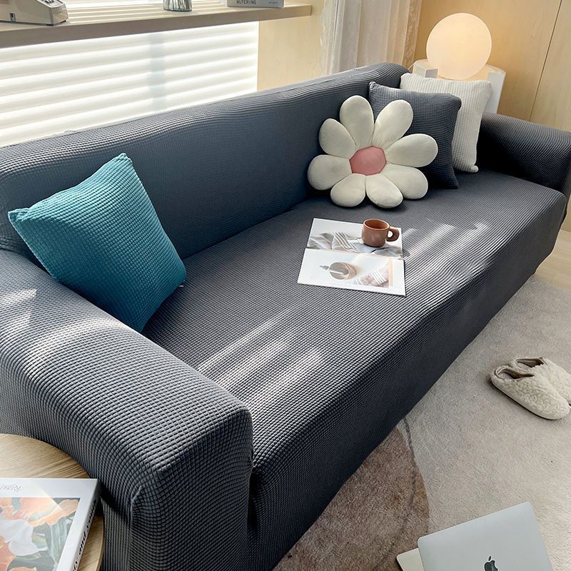 Bakside av sofa dekket med et teksturert stretch trekk som sitter godt.