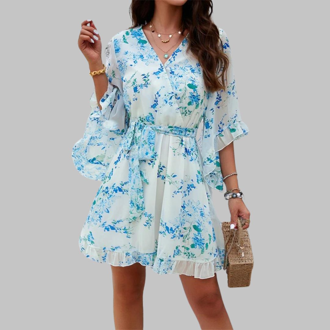 Modell går i lett blomster slå-om-kjole, perfekt sommerkjole i luftig polyester for feminin stil. [[lstfy-media:2]]