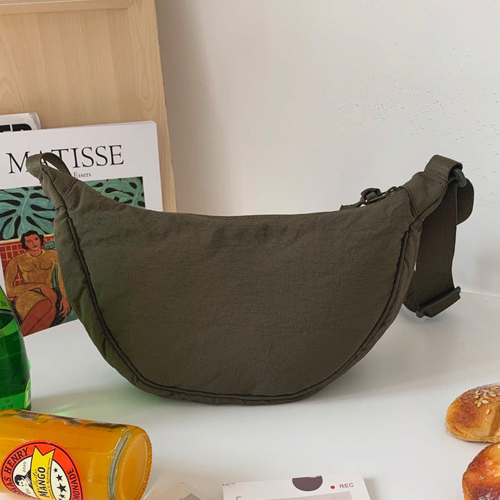 Romslig unisex halvmåneveske i nylon, mange lommer for organisert oppbevaring på reise.