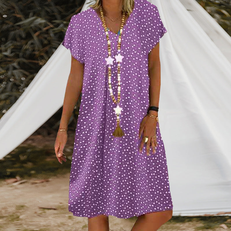 Stilig Feriekjole med Prikker. Lett og chic kortermet kjole med v-hals, ideell for reise og avslapning.