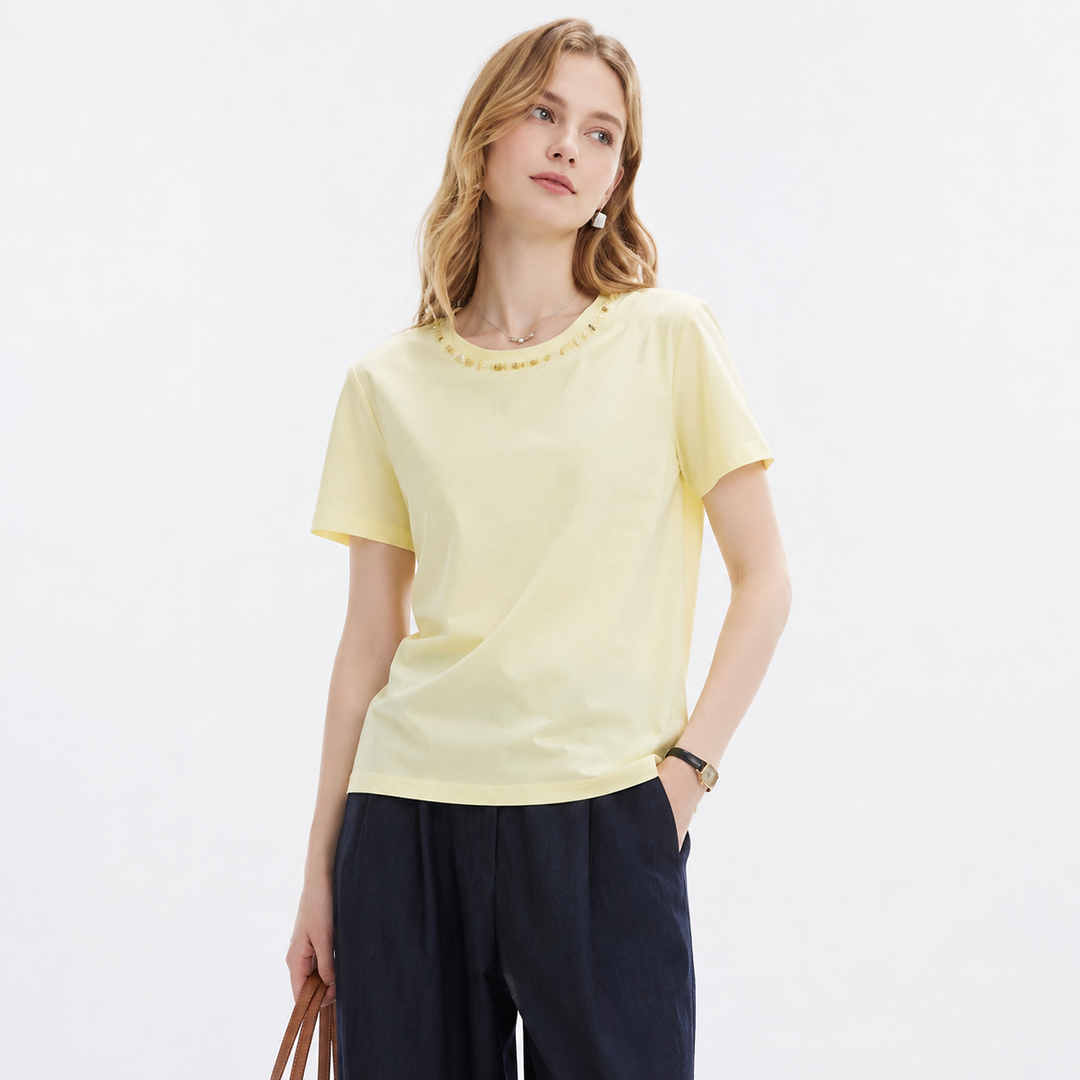 Avokadogul minimalistisk T-skjorte for dame med elegante perledetaljer. Perfekt sommertopp eller kontorantrekk.