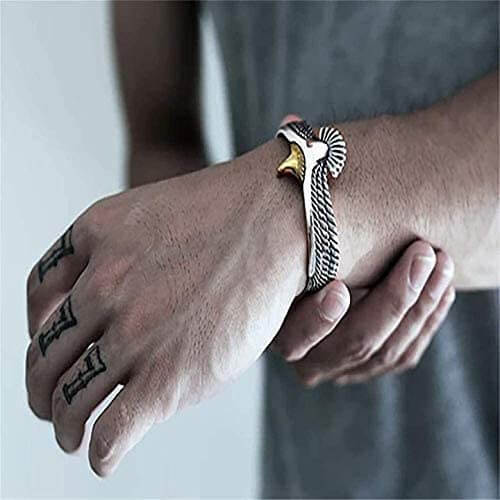 Nærbilde av detaljert ørn mansjettarmbånd, viser retro design og skinnende sølvbelagt finish. Elegant armbånd.