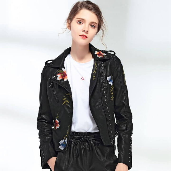 Trendy kvinnejakke med asymmetrisk kant og intrikate blomsterdetaljer, ideell for hverdagsbruk.