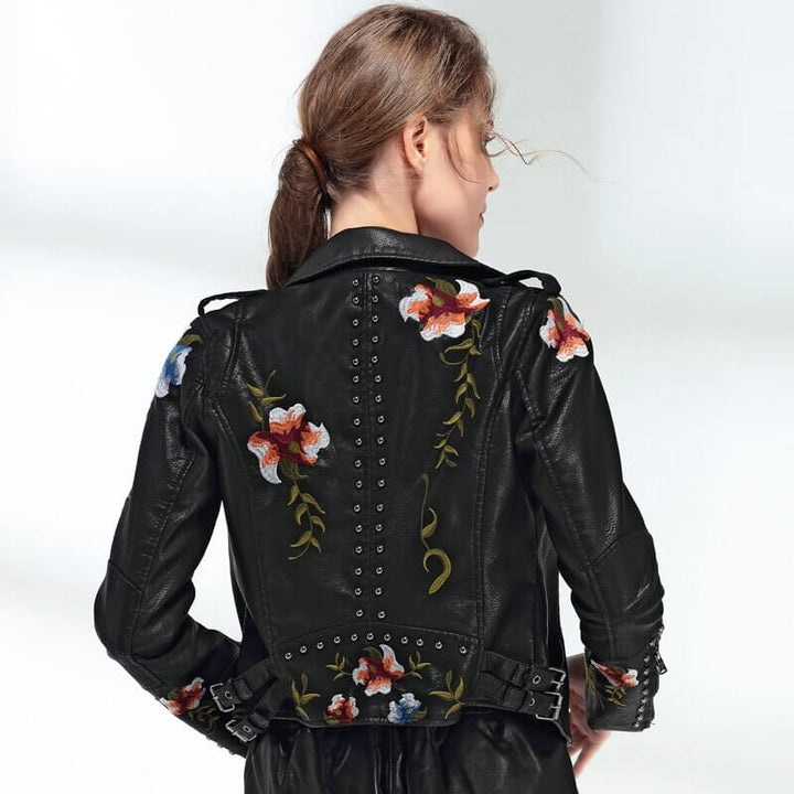 Kvinner jakke med unikt blomsterbroderi på ermet, asymmetrisk design og trendy stil.