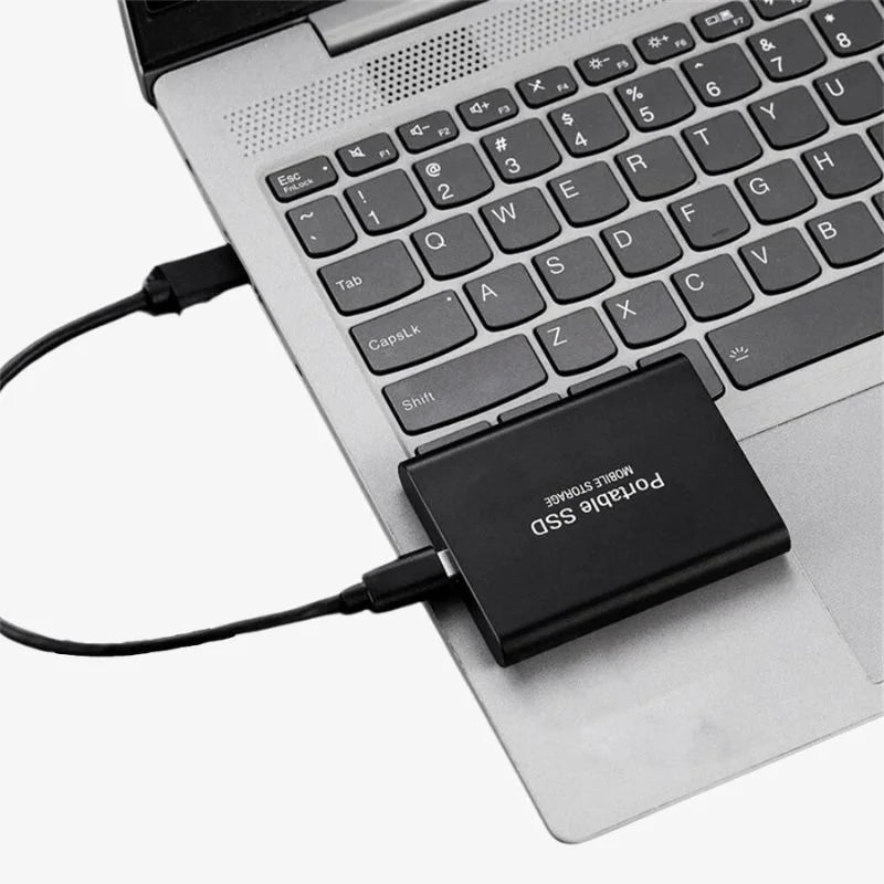 Liten bærbar SSD i hånd, fremhever kompakt design for enkel digital lagring.